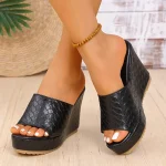 Sandale compensée sexy et antidérapante en cuir noir tressé pour femme.